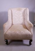 An antique wing armchair with shaped back, raised on cabriole supports with claw and ball feet and