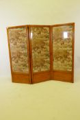 A C19th satinwood triple fold screen with glazed panels inset with a vintage printed textile