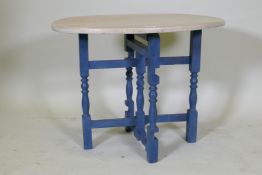 A painted oak folding table with oval limed top, 74 x 55cm, 56cm high