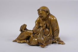 A Chinese filled brass figure of a seated lohan, 18cm wide