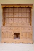 A pine dresser with an open delft rack, the base with two cupboards flanking a dog kennel, 158 x
