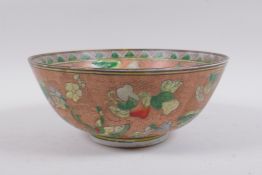 A Chinese peach ground porcelain bowl with famille verte enamel decoration of butterflies, flowers