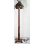 An Arts & Crafts Liberty & Co style coloured glass and wood standard lamp