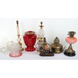 A good selection of table lamps, including two Victorian oil lamps with cranberry glass shades, one