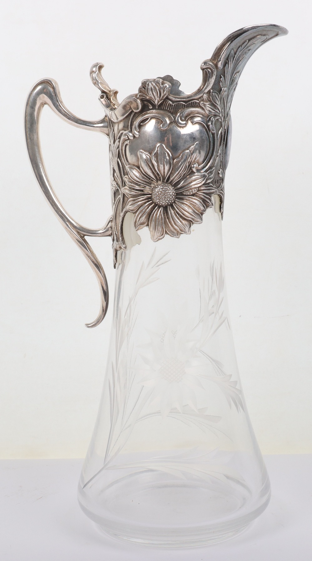 An Art Nouveau style silver and glass claret jug