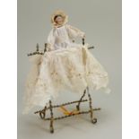 Miniature early wooden peg doll in gold painted folding crib, 1890s,