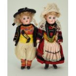 A pair of miniature bisque head dolls in regional costumes, German circa 1915,