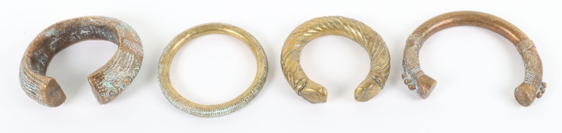 Four 18th century brass and bronze African bangles