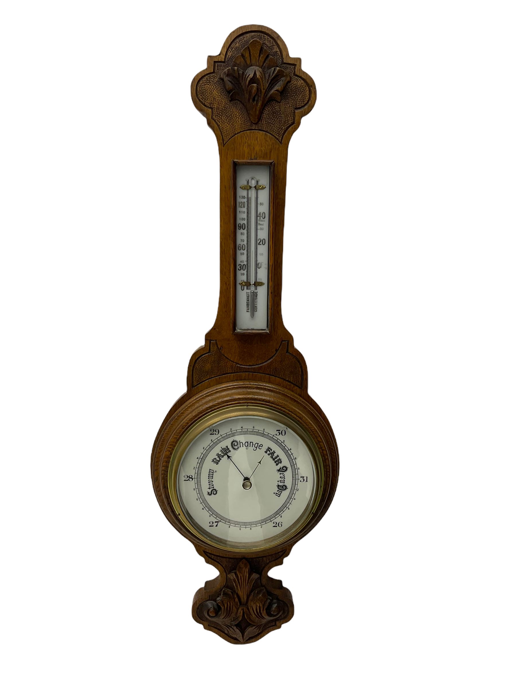 An English 1930's solid oak carved hall barometer in a scroll shaped carved case with relief carving