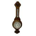 An English 1930's solid oak carved hall barometer in a scroll shaped carved case with relief carving