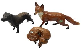 Three Beswick figures modelled as a fox in recumbent pose no.1017