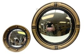 Two circular convex mirrors with gilded frames