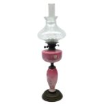 Pink opaline glass oil lamp of baluster form made with hand painted floral decoration upon a circula