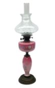 Pink opaline glass oil lamp of baluster form made with hand painted floral decoration upon a circula