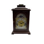 A 20th century Bracket clock in mahogany effect case with bell top pediment and glazed break arch d