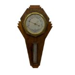 A mid-20th century British made aneroid barometer housed in an inverted oak case in the art deco sty