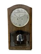 A mid 20th century German wall clock in a veneered mahogany case with a German eight day “Kienzle” m