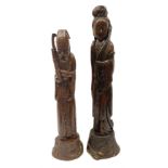 Two large hardwood Oriental figures carved as a man and woman donning robes upon naturalistic plinth