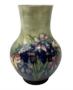 Moorcroft vase of baluster form decorated in the Spring Flowers pattern upon a merging green and blu