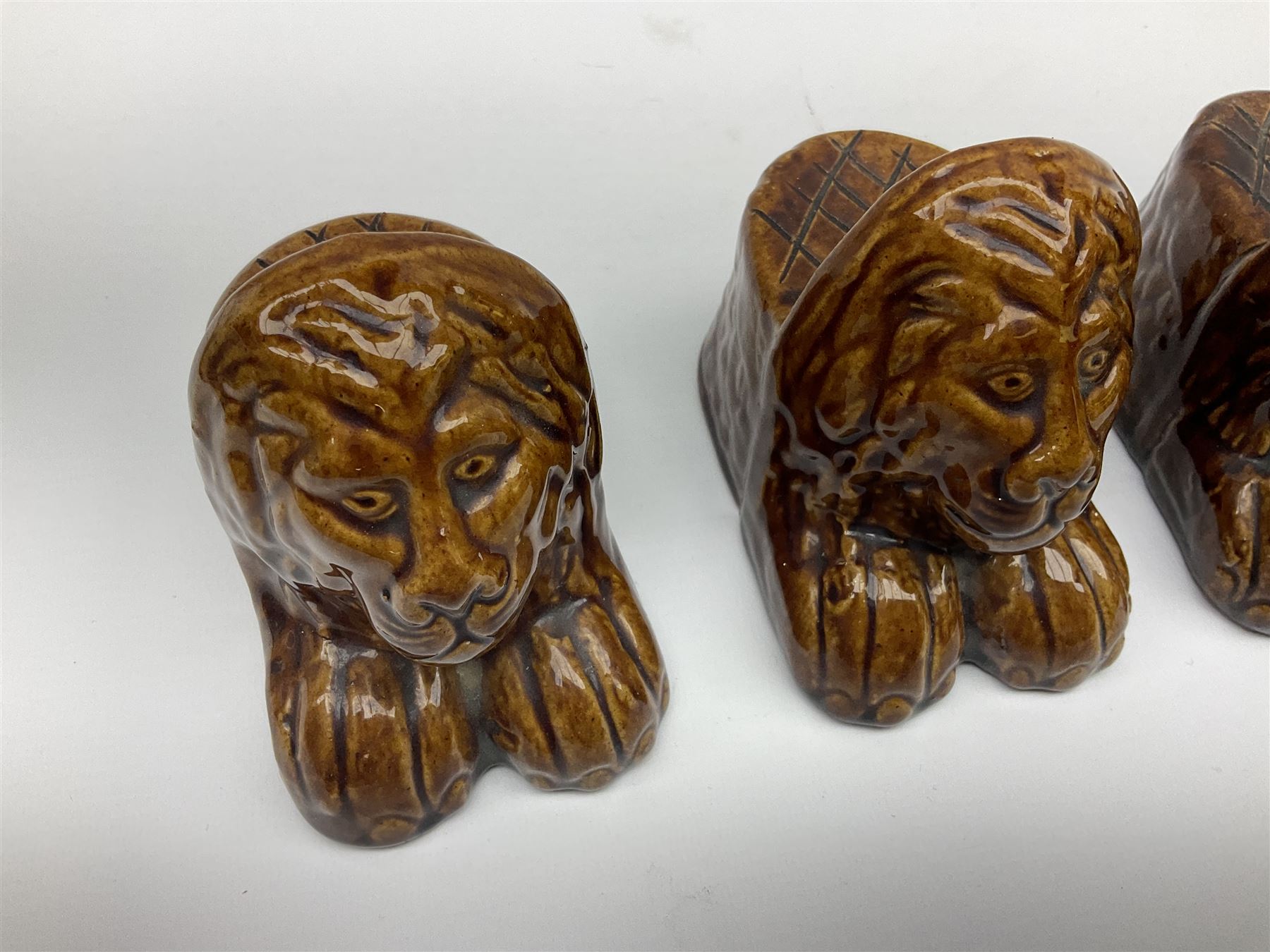 Set of four 19th century treacle glaze furniture/sash window rests modelled as lions
