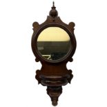 Mahogany wall bracket with circular mirror plate set against a shaped mahogany back with turned deta