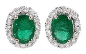 Pair of 18ct white gold oval emerald and round brilliant cut diamond cluster stud earrings