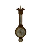 A contemporary German Aneroid barometer in a mahogany effect case with a broken pediment and finial