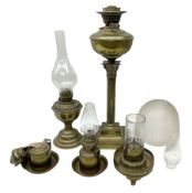 Five brass oil lamps to include Corinthian column example on stepped base with various glass funnel