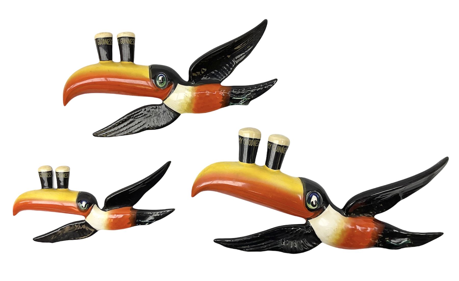 Set of three graduated Carlton Ware ceramic advertising wall plaques modelled as toucans balancing t