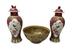 Pair of oriental famille rose vases of a baluster form with foo dog decoration on covers