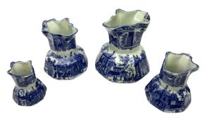 Set of four blue and white ironstone graduated jugs decorated with town scenes