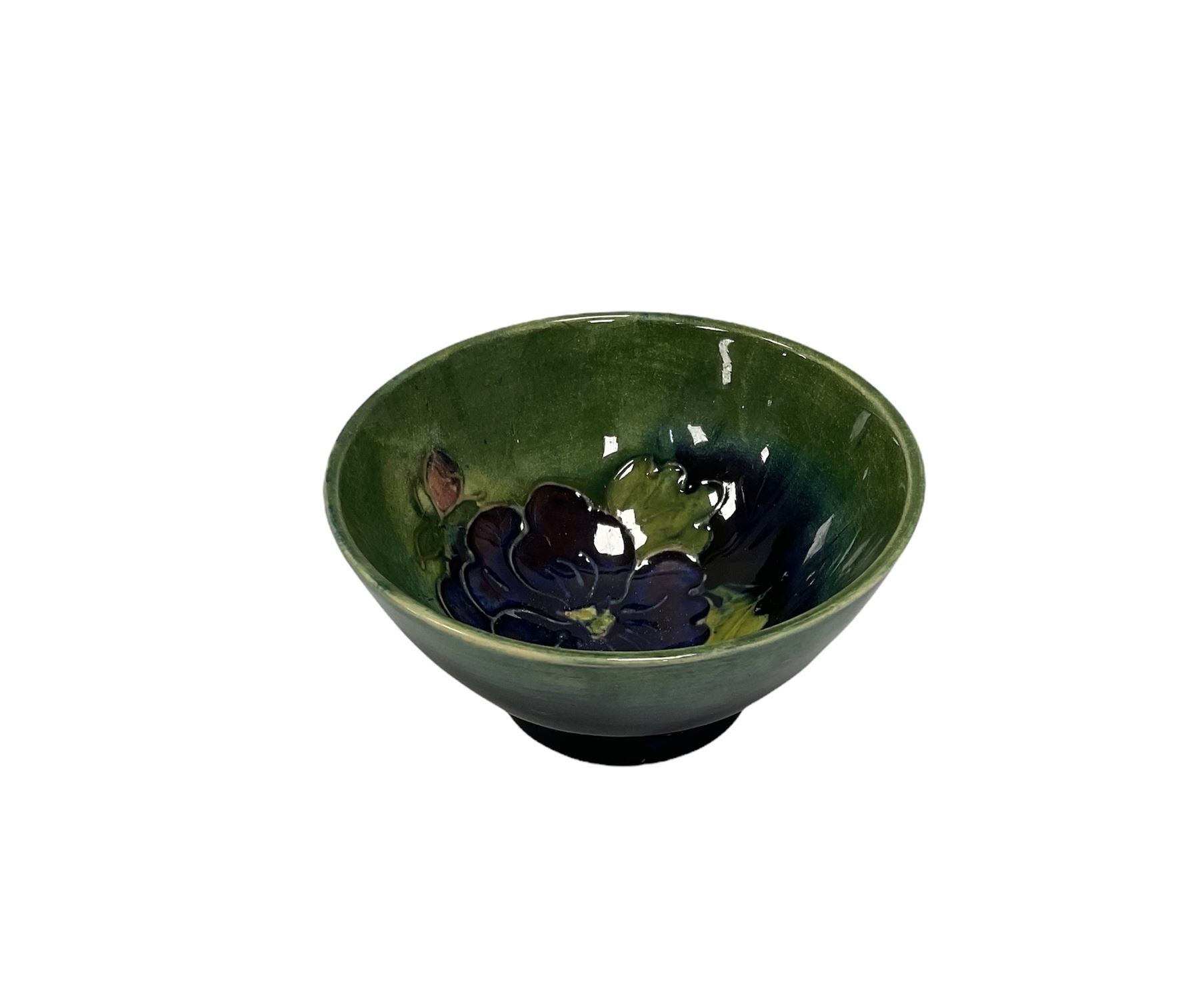 Small Moorcroft bowl decorated with dark blue flowers upon blue green ground