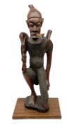 Large carved African figure of a man on one knee