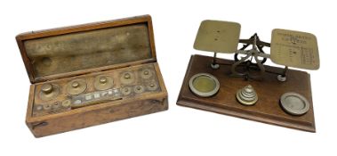 19th century cased set of Chemists' weights and tweezers and a set of brass postal scales on a foote