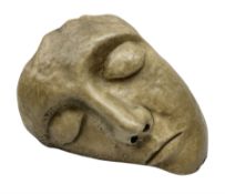 Carved stone sculpture of a serene sleeping head
