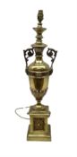 Gilt metal urn shaped lamp on stepped plinth base set with stylised foliate mounts