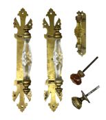 Pair of brass door handles with stylised fleur-de-lis motifs and cut glass handles
