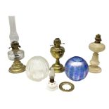 Four oil lamps to include brass example with clear glass reservoir