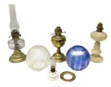 Four oil lamps to include brass example with clear glass reservoir