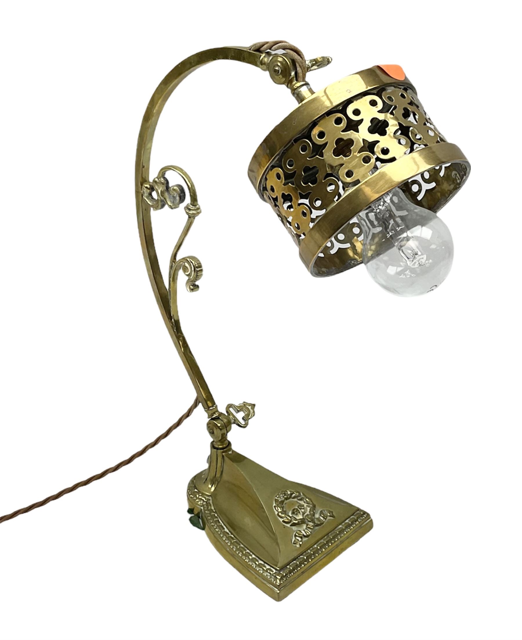 Brass adjustable wall light with a pierced shade and scroll decoration