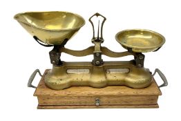 Pair of gilded iron scales mounted on wood twin handled base with drawer and quantity of brass weigh