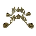 Two ornate brass wall sconces with twin branches modelled with cherubs playing trumpets