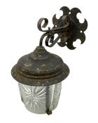 Wrought iron wall lantern with patterned glass shade of tapering cylindrical form