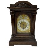A German carved oak cased mantle clock with a raised pediment