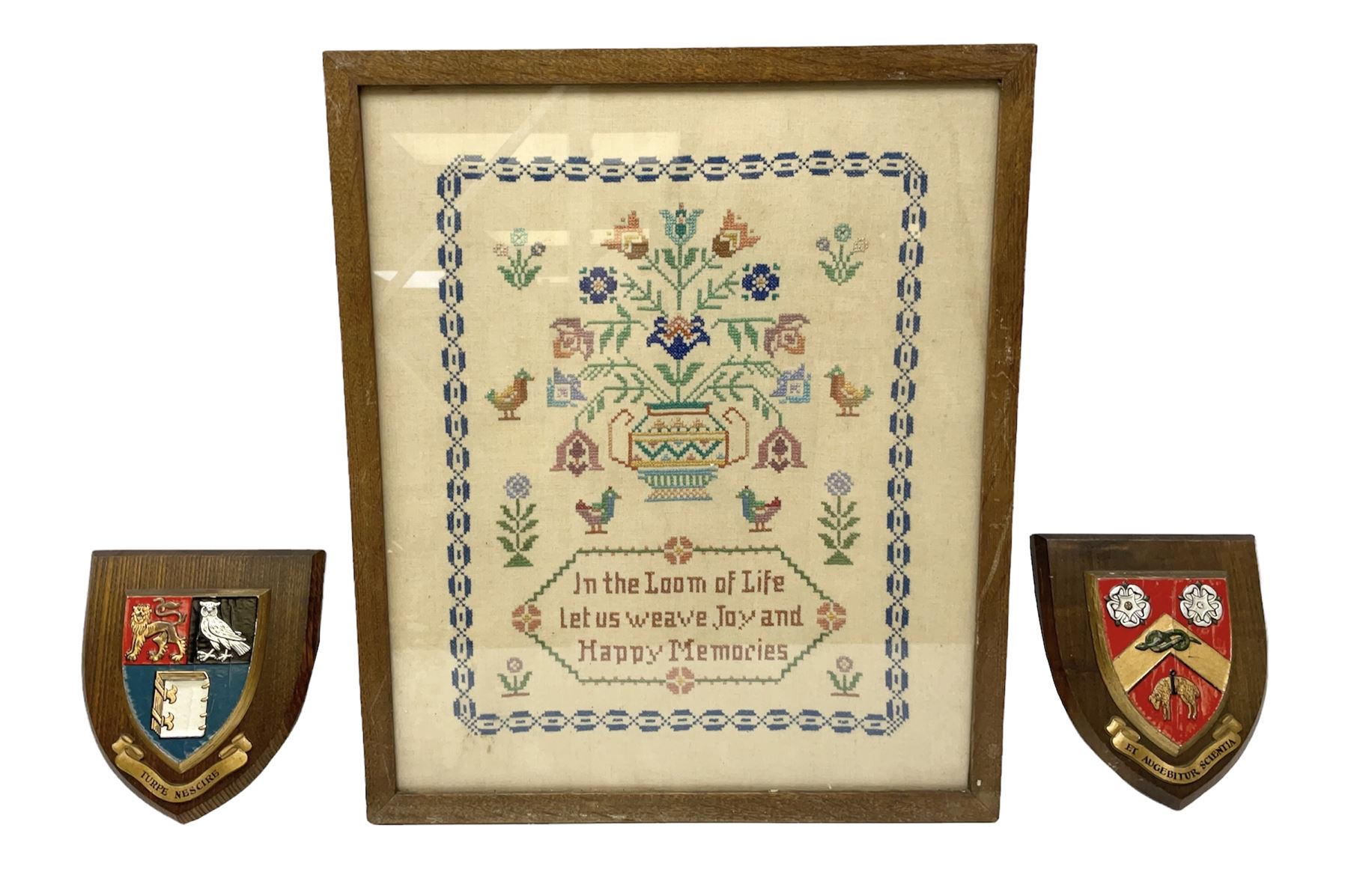 Framed sampler and two armorial plaques