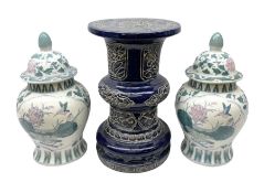 Oriental ceramics comprising blue jardeniere stand and pair of lidded urns decorated with blossoming