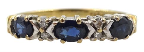 9ct gold three stone oval sapphire ring with four round brilliant cut diamonds set between