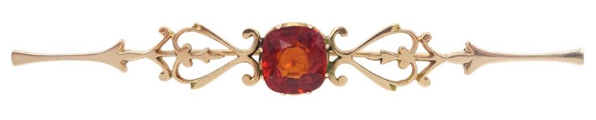 Early 20th century gold pierced heart design bar brooch set with a single cushion cut orange stone