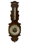 A carved oak cased aneroid barometer c1950 with an 8” open enamel dial, recording air pressure