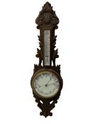A 1920s oak cased patented aneroid barometer with openwork decorative carving